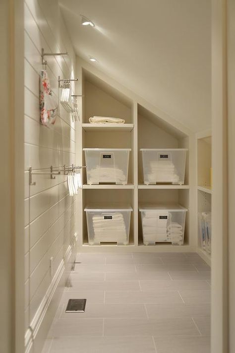 Cottage mudroom features a sloped ceiling fitted with pot lighting over built-in cubbies filled with clear storage bins alongside a wall of stacked clothes hooks lining a shiplap clad wall over a gray slate tiled floor. Angled Ceiling Closet, Cottage Laundry Room, Built In Cubbies, Angled Ceiling, Modern Laundry Rooms, Coastal Bathrooms, Cottage Interiors, Coastal Furniture, Custom Home Designs