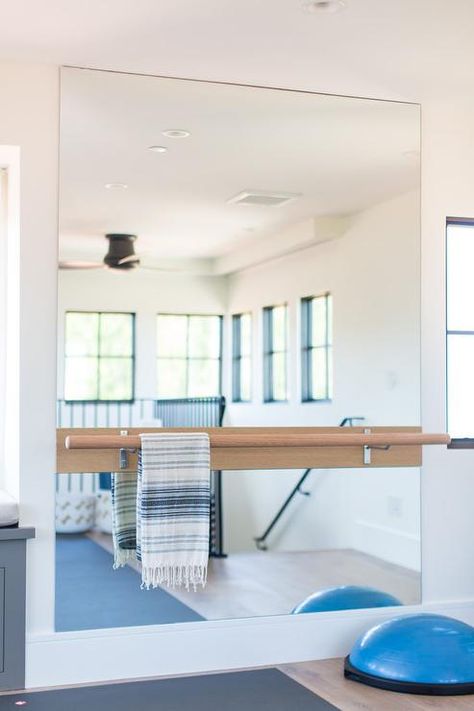 Ballet barre mounted on a large frameless mirror in a home gym featuring space for yoga and other various exercises uses. Home Gym Design Basement, Home Gym Mirrors, Home Dance Studio, Home Yoga Room, Home Gym Basement, Home Gym Garage, Workout Room Home, Gym Mirrors, Basement Gym