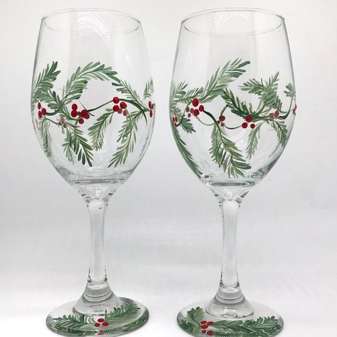 Our hand painted holly berry wine glasses make the perfect holiday hostess gift this holiday season. Add them to a gift bag or basket along with a bottle of the hosts favorite wine and you have a lovely gift for the host or hostess. Green garland and red holly berries circle the wine glass, adding a festive touch this winter while enjoying a glass of wine by the fireplace. A simple yet unique wine lover gift. ITEM DETAILS: 🤍The price shown is for 2 wine glasses 🤍Select size and style 🤍Each gl Hand Painted Christmas Glasses, Christmas Wine Glasses Diy, Painted Wine Glasses Christmas, Hand Painted Stemless Wine Glasses, Holiday Wine Glasses, Diy Wine Glasses Painted, Holiday Glassware, Glasses Ideas, Pretty Wine