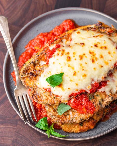 Chicken eggplant parmesan combines two iconic Italian-American dishes. Golden fried chicken cutlets are layered with marinara sauce, fried eggplant slices, Parmigiano Reggiano, and mozzarella.  Perfect for those nights where you can't decide between chicken or eggplant parm! #eggplantrecipes #chickenparm #eggplantparm #chickenandeggplantrecipes #chickendinner Eggplant Parmesan With Chicken, Chicken Eggplant Parmesan Recipe, Chicken And Eggplant Parmesan Casserole, Chicken Eggplant Recipe, Eggplant And Chicken Parmesan, Eggplant With Chicken Recipes, Egg Plant And Chicken Recipes, Chicken Eggplant Parmesan Baked, Eggplant Chicken Recipes