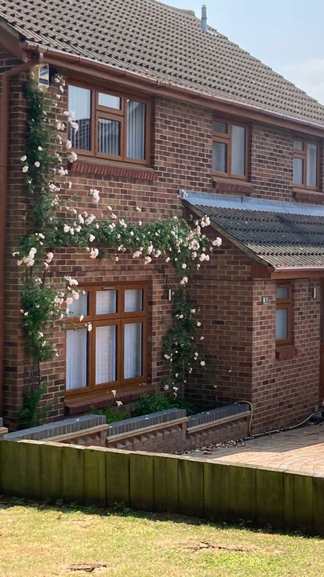 Brick house with flowers and leafs on the house surrounding the windows. Country house aesthetic Cute Brick House, Vines On Brick House, Brick House Aesthetic, Home Town Country House, Brick House With Vines, Aesthetic Town House Exterior, Old Money Brick House, Country House Aesthetic, Old Brick House