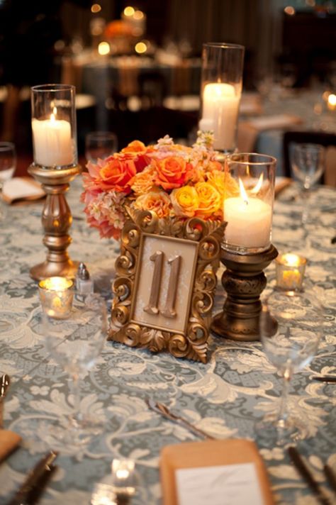 Gold-Bronze-Orange-Centerpiece Flower Arrangements Fall, Peach Wedding Centerpieces, Blue Fall Wedding, Orange Centerpieces, Candles And Flowers, Framed Table Numbers, Deco Orange, Flowers And Candles, Gold Candle Sticks