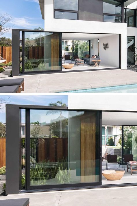 A full-height wall-to-wall glass door with a black frame, opens up the living room of this modern house and connects it to the patio that surrounds the pool. #GlassWall #Architecture #SlidingWall #ModernHouse Living Room With Glass Wall, Room With Glass Wall, Architecture Cool, Walls Decor, Sliding Wall, Modern House Facades, Glass Walls, Casa Container, Modern Windows