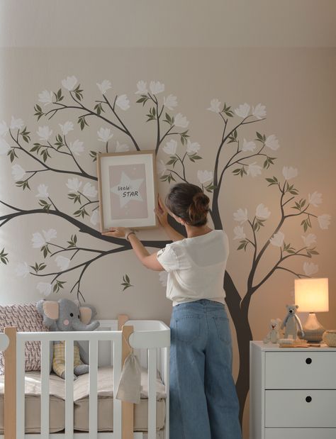 Suit up your kids' room with our unique Flowers Tree Wall Decal. This detailed, vibrant decal of magnolia flower drifting in the air will transform your empty, boring wall into a cozy nursery. Give your home a bold new look today! Floral Accent Wall Nursery, Gender Neutral Nursery Mural, Nursery With Mural, Tree Painting On The Wall, Nursery Tree Mural, Baby Room Wall Painting, Nursery Wall Color, Eloise Bedroom, Nursery Mural Ideas