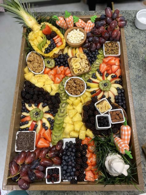 This charcuterie board has pineapple, kiwi, grapes, apples, berries, nuts granola, and chocolate chips. We have bunny, grass, and carrot decorations to give it the spring look. Pineapple Charcuterie Board, Luau Charcuterie Board Ideas, Hawaiian Themed Charcuterie Board, Luau Charcuterie Board, Hawaiian Charcuterie Board, Sweet Boards, Carrot Decorations, Charcuterie Fruit, Fruit Boards