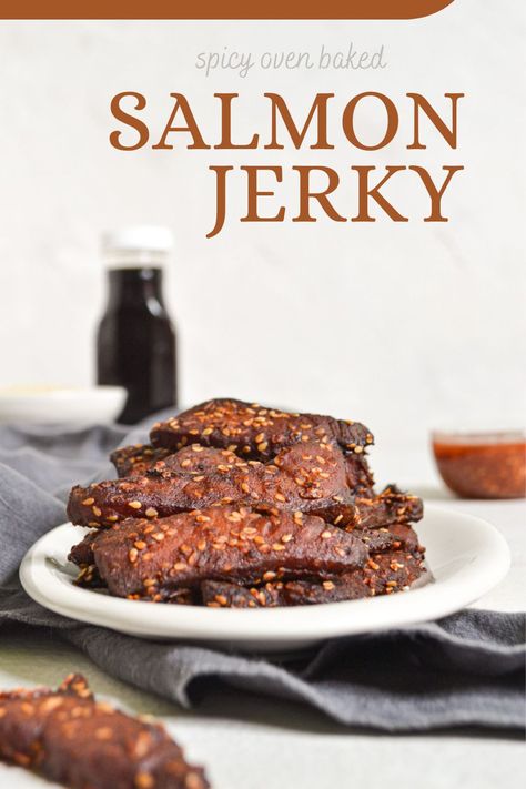 An oval plate full of dehydrated salmon; with a towel, bottle of soy sauce, bowls of sesame seeds and chili garlic sauce in background. Dehydrated Salmon Jerky, Salmon Jerky Dehydrator, Salmon Jerky, Best Dehydrator Recipes, Salmon Jerky Recipe, Salmon Snack, Oven Jerky, Fish Jerky, Jerkey Recipes