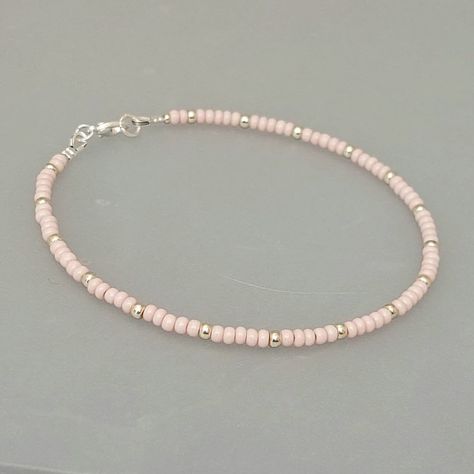 "This baby pink seed bead anklet has been lovingly made using glass 3mm opaque pink Preciosa seed beads.  Highlighted with 3mm Miyuki seed beads in a choice of silver or gold. Threaded on strong stainless steel 7 strand Tiger Tail wire and finished with silver/gold plated wire guardians and a lobster clasp, making it easy to put on & take off. With an optional 2\" Silver/gold plated extender chain so you can wear the anklet to sit where you feel most comfortable. I make these in various sizes in Pink Beaded Anklet, Cute Seed Bead Bracelets, Pink Seed Bead Bracelet, Seed Bead Anklet, Anklets Diy, Small Bead Bracelet, Pink Beaded Bracelets, White Beads Bracelet, Tiger Tail