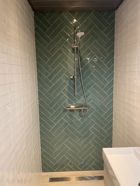 Green Chevron Tile Bathroom, Dark Green Herringbone Tiles, Herringbone Shower Panel, Dark Green Herringbone Tiles Bathroom, Sage Herringbone Tile Bathroom, Herring Bone Tiles Bathroom, Bathroom With Herringbone Tile, Herringbone Shower Accent Wall, Green Tiles Toilet