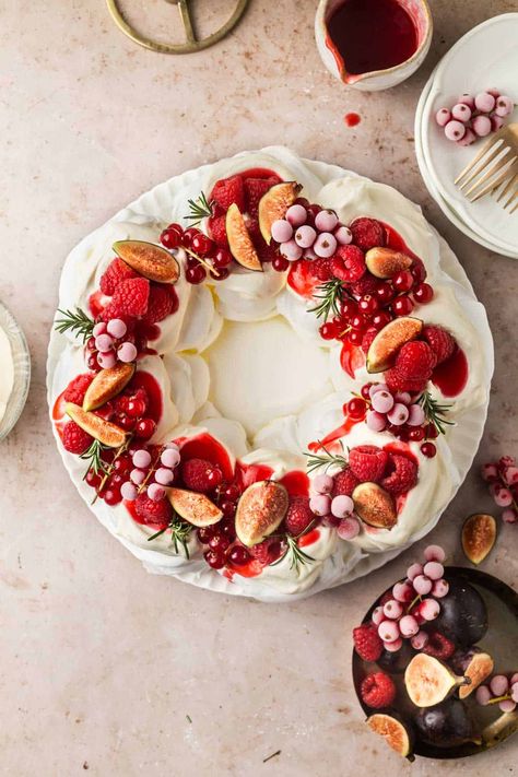 This show-stopping Christmas Pavlova Meringue Wreath is deceptively simple to make. Crisp meringue with a pillowy interior is topped with whipped cream and fresh fruit. A stunning dessert. Christmas Pavlova Recipe, Christmas Pavlova Wreath, Pavlova Wreath, Gluten Free Christmas Desserts, Christmas Pavlova, Holiday Baking List, Christmas Dessert Table, Raspberry Coulis, Pavlova Recipe