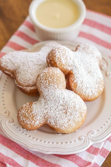 These beignets are fried pastries, shaped with a Mickey cookie cutter, sprinkled with powdered sugar and served with a vanilla cream sauce. Disney Beignets, Cream Anglaise, Mickey Beignets, Julep Recipe, Dole Whip Recipe, Disney Dishes, Beignet Recipe, Ultimate Grilled Cheese, Disney Desserts