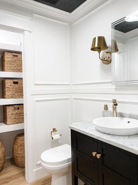 White box trim walls, a black vanity with marble counter, semi recessed vessel sink and brass fixtures Powder Room Box Trim, Box Trim Bathroom, Black And White Powder Room, White Powder Room, Box Trim, White Vessel Sink, Mirror Sconces, Semi Recessed Sink, Black Vanity Bathroom