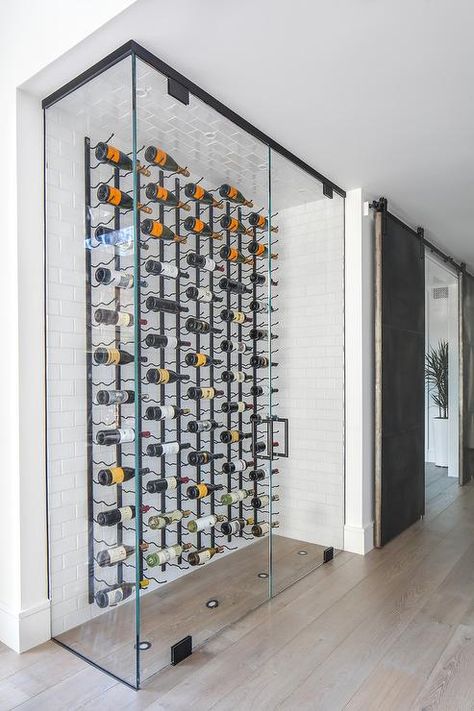 Modern wine cellar features a glass-enclosure displaying vertical wine racks mounted on white subway tiles. Contemporary Wine Cellar, Custom Wine Rack, Glass Wine Cellar, Wine Closet, Modern Coastal Home, Home Wine Cellars, Wine Cellar Design, Cellar Design, Coastal Modern