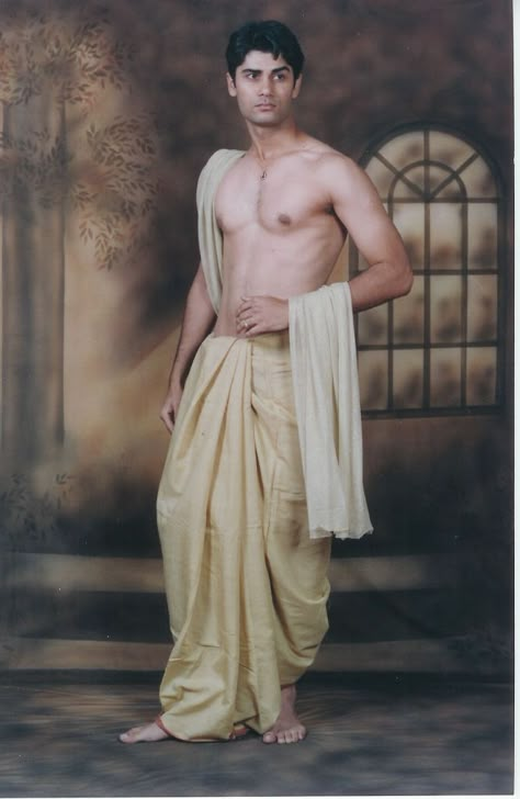 Dhoti: Also called pancha, mardani, suriya or veshti, is a piece of cloth, usually 4.5 metres long, wrapped around and knotted at the waist. In India, dhoti is worn in Tamil Nadu, Kerala, Andhra Pradesh, Maharastra, Karnataka, Bihar, Madhya Pradesh, Assam, West Bengal, Odisha, Konkan and Goa. Its often worn with a top which is called a kediya in parts of Gujarat and Rajasthan, kurta in Bihar, punjabi in Bengal and Assam, sattai in Tamilnadu and chokka or jubba in Andhra Pradesh Clothes Men, Straight Jacket, Indian Man, Foto Poses, Madhya Pradesh, Indian Clothes, Poses References, Indian Clothing, Human Poses