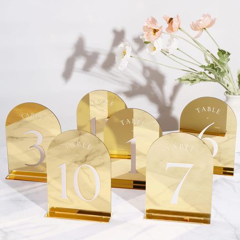 PRICES MAY VARY. Minimalistic Design: Arch wedding decor is a new trending and minimalist will never go out of style. These arch gold mirror acrylic table number with holders are best choice for your wedding reception. Premium Quality: These modern table numbers are made out of high quality acrylic sheet, the lettering is white paint to make it more beautiful and long lasting. For Many Occasions: Whether you are celebrating a wedding, birthday, bridal shower, baby shower, anniversaries, engageme Mirror Arch, Reception Signage, Gold Table Numbers, Acrylic Table Number, Arch Wedding, Anniversary Event, Elegant Centerpieces, Acrylic Table, Decoration Party