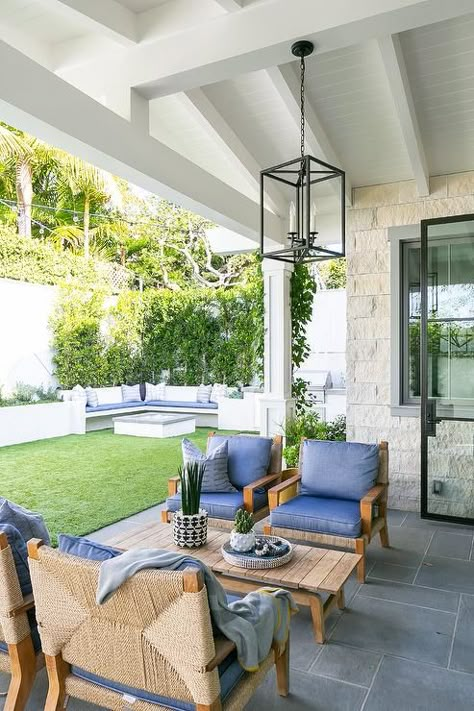 An oil rubbed bronze lantern hangs from a covered patio ceiling over a teak slatted coffee table flanked by side-by-side teak and rope chairs placed on slate pavers and matched with blue cushions. Brooke Wagner Design, Brooke Wagner, Outdoor Lounge Area, Trendy Home, Home Style, Raised Beds, Outdoor Rooms, Residential Design, Patio Furniture Sets