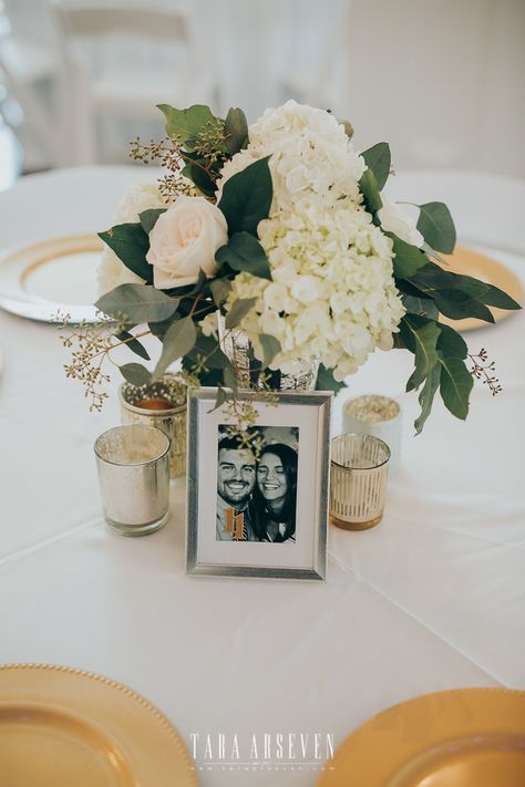 | modern wedding centerpiece | gold + white wedding reception decorations | white wedding flower centerpiece | gold wedding table settings | elegant wedding centerpiece with flowers + small candles | brides of north texas | photo taken at THE SPRINGS Event Venue. follow this pin to our website for more information, or to book your free tour! SPRINGS location: Rockwall Manor in Rockwall, TX photographer: Kevin Paul Photography #weddingcenterpiece #weddingdecor #weddingdecorations #whiteweddings Wedding Table Picture Centerpieces, Wedding Table Decor With Pictures, Ivory And Gold Centerpieces, Wedding Centerpieces With Pictures, Picture Centerpieces Wedding, Picture Centerpiece Ideas, Wedding Table Settings Elegant, Candle Table Setting, Picture Centerpieces