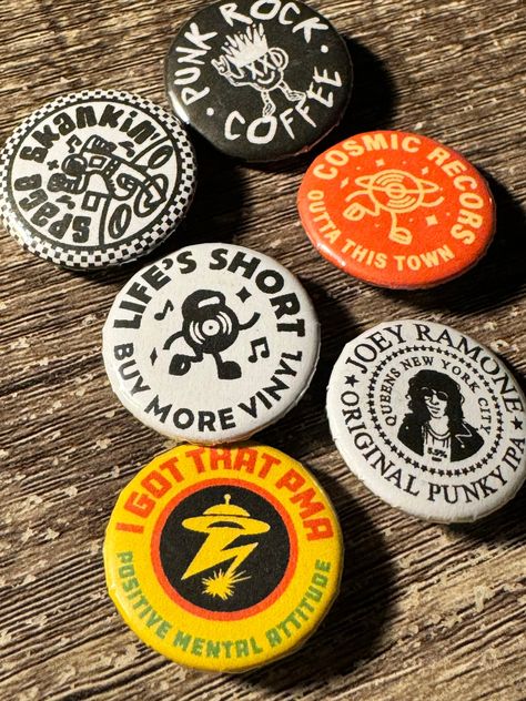 A collection of music inspired badges, based around my love for records and punk rock. Hand pressed by myself.  The pack includes:  * I got that PMA button badge (Bad Brains inspired) * Life's short buy more vinyl * Cosmic records  * Punk rock coffee * Space Skankin   * Joey Ramone original punky IPA * 25mm size * Metal badge case and plastic backer with pin  Free stickers with all orders. Design by: Jake Warrilow Punk Button Pins, Pins Design Button, Button Designs Ideas, Diy Pins Buttons, Button Pins Design, Button Pin Design Ideas, Button Badge Design, Pin Badge Design, Sticker Pack Design