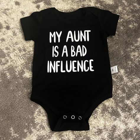 This Listing Is For A Baby Short Sleeve Unisex Onesie. It Is Black On The Front In White Letters It Says, "My Aunt Is A Bad Influence." It Is Unbranded, Size 9 Months. This Onesie Is New Without Tags. It Comes From A Non-Smoking Home. I Will Accept Reasonable Offers On Some Items. I Don’t Discount New Items.. And Will Not Take 50% Off Offers. Baby Onsies Ideas, Aunt Onesie, Onesie Ideas, Auntie Baby, Funny Baby Shirts, Baby Aunt, Goat Barn, Baby Shower Theme Decorations