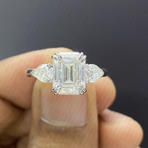 Emerald Cut Moissanite 14K White Gold Engagement Ring, Side Pear Cut Moissanite Ring, Three Stone Wedding Ring, Double Prong Anniversary Ring Available On Etsy https://www.etsy.com/in-en/listing/1742621612/emerald-cut-moissanite-14k-white-gold?click_key=17312d6b4cfce15489d2a58e918c23e2293f7644%3A1742621612&click_sum=eecca5c9&ref=shop_home_active_1&pro=1&frs=1 Stone Details: Main Stone Size: 9x7mm Emerald Cut Moissanite Side Stone: Pear Cut Moissanite Cut: Excellent Color: DEF Clarity: VVS1... Emerald Cut Moissanite, Three Stone Ring, Etsy Wedding Rings, Ring Emerald, Engagement Wedding Ring, Ring Promise, White Gold Ring, Three Stone Rings, Moissanite Rings