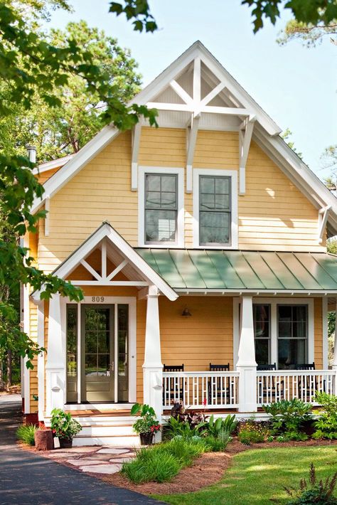 A classic farmhouse takes a contemporary turn thanks to a refreshingly cheerful color palette. A soft apricot exterior paint sets the siding aglow, glossy white paint highlights the home's vintage details, and smoky gray paint adds visual weight to the front door and window sashes. #exteriorpaintcolorsforhouse #homeremodel #colorschemes #dark #brick #bhg Contemporary Front Porch, Yellow House Exterior, Exterior Color Combinations, House Paint Color Combination, Exterior House Paint Color Combinations, House Outdoor, Farmhouse Landscaping, Pastel House, Yellow House