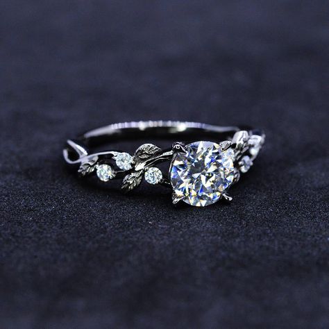 The default design option features 7mm Giliarto Moissanite Center Stone D - Color, SI1-Clarity, VG-Cut, Ex-Polish, VG-Symmetry and 0.2 TC Accents in 14K Black Gold Engagement Ring. Also you can fully customize and engrave this ring by clicking the button "Personalize in 3D". Model As well please remember it takes up to 19 days to make and ship this item. Engagement Rings Diamond Silver, Engagement Rings Floral Band, Wedding Rings Engagement Floral, Rings Engagement Floral, Engagement Rings Diamond And Sapphire, Dainty White Gold Engagement Ring, Nature Inspired Engagement Rings Giliarto, Floral Gold Ring, Pretty Engagement Rings Silver