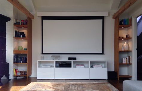 How to hide the TV - projector with screen! The screen can be rolled up and hidden in the custom made box (white box on top). The screen  has a 5 cm distance from the wall making it possible to hang art on the back of the screen. Roll Down Projector Screen, Hide Projector Screen, Projection Screen Living Room, Screen Projector Ideas, Living Room Projector Wall, Hidden Projector Screen, Projector Screen Living Room, Projector Ideas, Projector Wall