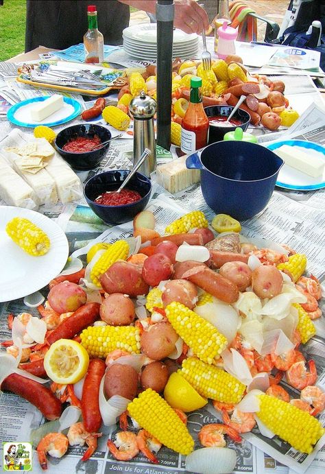 A party table with a spread of Cajun seafood boil with potatoes, corn, lemons, shrimp, and sausage. Fish Fry Party, Cajun Party, Low Country Boil Recipe, Shrimp Boil Party, Low Country Boil Party, Crab Boil Party, Low Boil, Cajun Seafood Boil, Seafood Boil Party