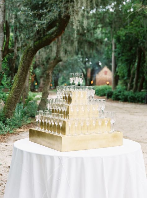 This gold display is a beautiful way to serve your bubbly for your wedding. Champagne towers are glamorous and make a statement at the entrance of your reception, and definitely a totally camera-ready. This is one of my favorite wedding Champagne tower ideas. Perfect for your cocktail hour and an elegant way to toast the newlyweds. Another ideas is to showcase your champagne glasses with your seating display. Place the escort cards directly on the glass for your guests, an elegant display. Champagne Flute Stand, Wedding Entrance Champagne, Champagne Wedding Entrance, Champagne Toast Display, Champagne Glass Display Party Ideas, Champagne Table Display Wedding, Champagne Serving Ideas, Cocktail Hour Drink Display, Champagne Entrance Wedding