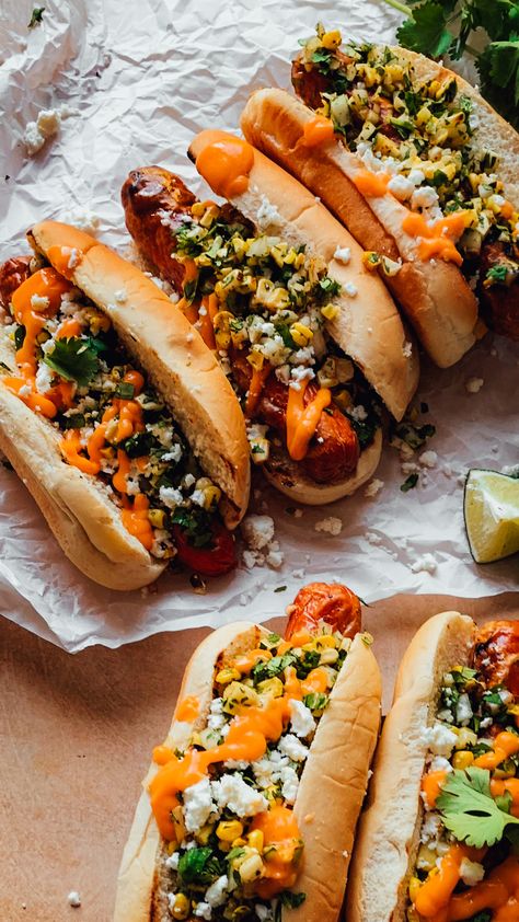 These Elote Dogs are perfect for summer grilling. Dressed up Mexican street corn style, jumbo hot dogs are filled with charred sweet corn, chopped onion, and fresh cilantro all seasoned with chili powder and some crumbled cheese with a final drizzle of chipotle aioli for the ultimate gourmet dog! These dogs are all done on the BBQ in record time and perfect for the summer season ahead! Jumbo Hot Dog, Elote Hot Dog, Food Truck Appetizers, Elevated Hot Dogs, Mexican Hotdogs, Fancy Hot Dogs, Gourmet Hot Dogs Toppings, Hot Dog Ideas, Gourmet Hotdogs