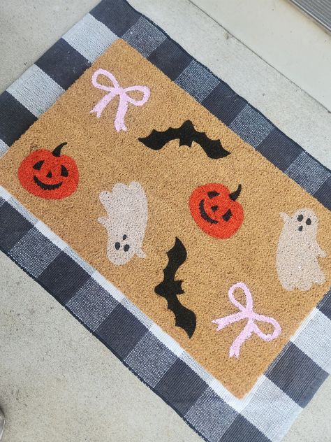 The cutest girly core Halloween mat ever!  This adorable mat features ghosties, jack o lanterns, bats and some pink bows for a girly touch.  The doormats are 100% coir with a sturdy rubber backing. I handpaint and seal the mats for protection. Mats are 18x30". Each mat is unique. Fibers may be thicker or thinner or there may be small chunks of coconut husks in the fibers. Mats are best placed in a covered area away from the elements. I do not recommend placing your mat in areas with direct sunli Halloween Mats Diy, Halloween Rugs Diy, Comfy Room Ideas, Mat Painting, Halloween Mat, Girly Core, Halloween Rugs, Comfy Room, Halloween Emoji