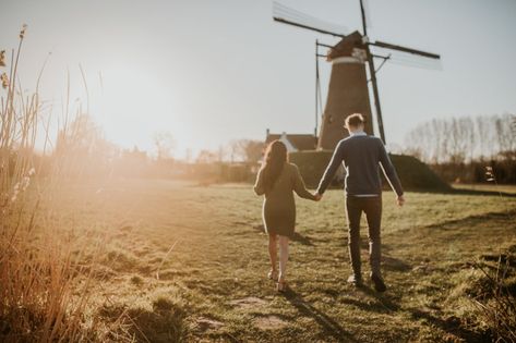 Engagement photoshoot at the dutch windmill at golden hour Eindhoven Golden Hour Couple, Dutch Countryside, Walking Together, Dutch Windmill, Couple Walking, Dutch Windmills, Couples Walking, Walk Together, Couple Photoshoot