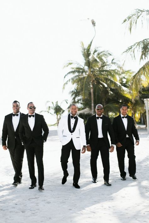 groomsmen in black and groom in white jacket Grooms In White Tuxedos, Black And White Tuxedo Wedding Groomsmen, White Groom Black Groomsmen, Bride And Groom In All White, White And Black Groomsmen Attire, Groom And Bride In White, Groom In White Jacket, Black And White Suit For Men Wedding, Bride And Groom White Attire