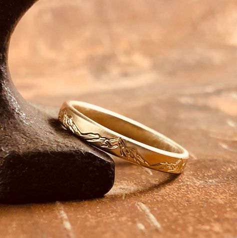 "A mountain range design is engraved around the outside of this 14k yellow gold ring. Great for the nature lover who wants a simple band. The mountains are more subtle on this band because it's not darkened to accentuate them like my sterling silver version. This listing is for one 3 mm wide x 1.5 mm thick band Brushed, rustic finish Solid 14k yellow gold Understated but substantial, this 3 mm band is weathered perfection. Besides being hand-fabricated and made to order in exactly your size (inc Engraved Rings For Him, Flat Wedding Rings, Earthy Engagement Rings, Earthy Wedding Rings, Mountain Engagement Ring, Mountain Wedding Band, Mountain Rings, Mountain Wedding Ring, Nature Inspired Wedding Ring