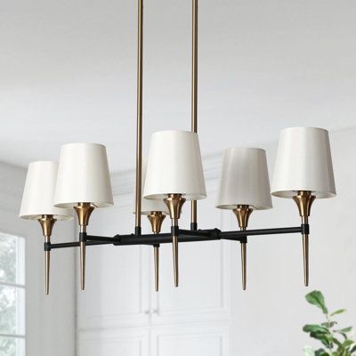 Introduce an approachable sense of refinement to your modern farmhouse dining room or entryway with this unique six-light Transitional Traditional linear chandelier, featuring dramatic curves and a striking two-tone finish of black and aged brass. The modern, industrial design highlights a mixed metal aesthetic and stark white shades, while the white drum shade ensures soft, even illumination. With tassel details attached by brass loops, the transitional style with each figure exudes a sleek per Modern Farmhouse Dining Room, Modern Farmhouse Dining, Hampton House, House Lighting, Linear Pendant Light, Kitchen Island Linear Pendant, Light Kitchen Island, Light Kitchen, Traditional Chandelier