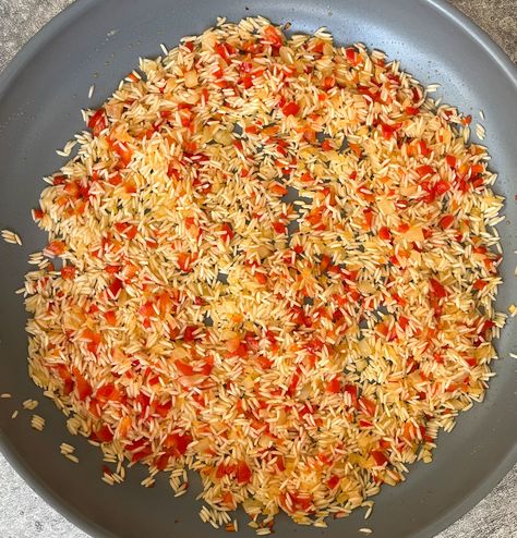 There is chopped onion, red bell pepper, and white rice cooking in a large gray skillet. Garlic Rice Pilaf, Bell Pepper Rice, Chile Relleno Casserole Recipe, Starchy Sides, Pepper Rice, Cook Salmon, Chicken Piccata Recipe, Longhorn Steakhouse, Garlic Rice