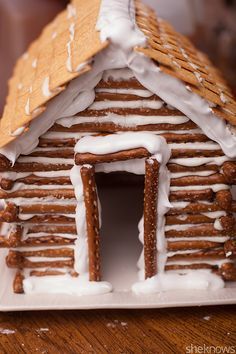 pretzel-log-cabin-tutorial Pretzel House, Pretzel Log Cabin, Pretzel Gingerbread House, Edible Snow, Graham Cracker Gingerbread, Holiday Pretzels, Graham Cracker Gingerbread House, Homemade Gingerbread House, Piping Frosting