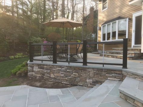 A beautiful composite post and cable rail fence on blue stone patio deck in Smithtown. Fence Around Concrete Patio, Cement Decks Patio, Trek Patio Ideas, Back Patio Railing Ideas, Raised Cement Deck, Stone Back Deck Ideas, Paver Patio Railing Ideas, Concrete Patio Railing, Elevated Concrete Patio