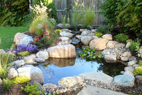 The waterfall is in proportion to this smaller pond, nestled snug against the corner of a patio. Small Water Gardens, Taman Air, Rock Plants, Diy Pond, Small Pond, Fountains Backyard, Pond Waterfall, Pond Water Features, Pond Landscaping