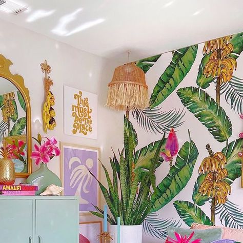 Sarah Caligiuri ☀️🌴🌙 on Instagram: "Lounge Vibes💚 I love small spaces. They are cozy & can even feel larger when you create a statement wall. Adding this bold peel & stick wallpaper actually makes it feel bigger than it is. Forever adore this tropical banana print. Also wanted to share, I have my own storefront over @revival (link in bio) where you can exclusively get 15% off their entire site. So exciting! They have one of the best selections out there. This beautiful plush rug tied the entire room together👌 Happy Thursday. Hope you have a great one! . . . . #cozyhomedecor #homedecorideas #boldbohemians #modernboho #prettylittleinteriors #smallspaces #diyhomedecor #colorfulhome #myplantlovinghome #howihome #colorfuldecor #interiordesigninspo" Tropical Glam Decor, Tropical Apartment, Lounge Vibes, Palm Beach Decor, Painted Dressers, Chic Office Decor, Tropical Glam, Glam Bedroom, Banana Print