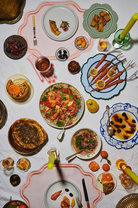 A Moroccan-inspired table setting with colorful plates set on a white linen tablecloth and a variety of dishes including an orange & olive salad, goat cheese cigars, and tagines. Moroccan Dinner Party, Indian Dinner Party, Moroccan Dinner, Moroccan Salad, Moroccan Party, Indian Dinner, Citrus Salad, Salad Dishes, Dried Vegetables