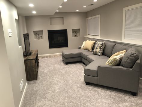 Long narrow basement family room. Minimalist. Gray sectional. Basement Narrow Living Room, Basement Ideas Long And Narrow, Long And Narrow Basement Ideas, Long Narrow Basement Family Room, Narrow Long Basement Ideas, Long Narrow Living Room Sectional Couch, Long Narrow Basement Layout, Small Narrow Basement, Small Narrow Basement Ideas