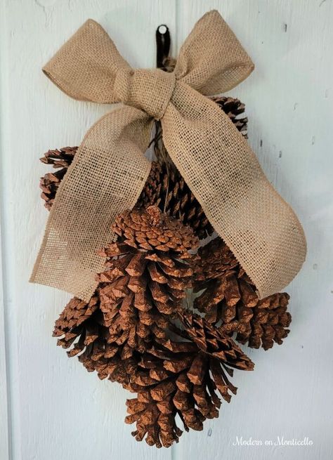 Pine Cone Door Swag, Pine Cone Door Hanger, Pine Cone Swags, Fall Pine Cone Decorations, Crafts With Large Pinecones, Pinecone Swag Diy, Large Pinecones Ideas, Crafts With Pine Cones, Gold Glitter Spray Paint