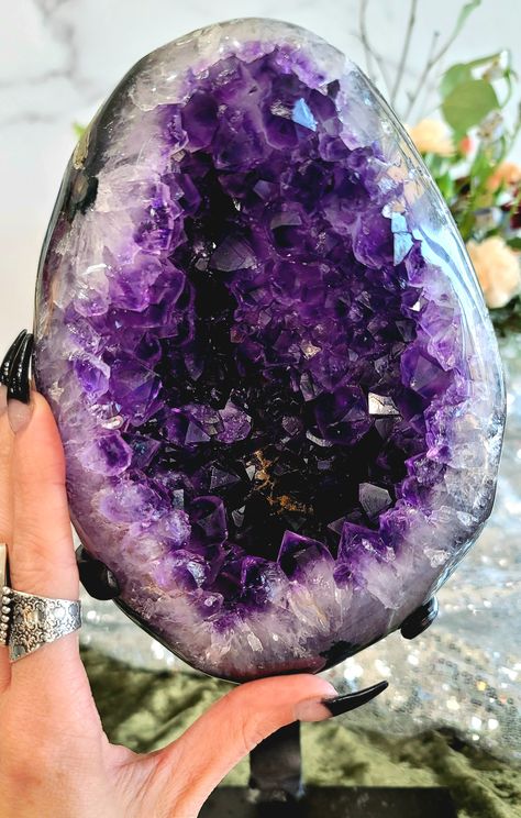 A stunning Uruguayan Amethyst Geode on display stand. ♡ Chakra: Third Eye & Crown ♡ Brings calmness and clarity to the mind ♡ Enhances intuition & wisdom ♡ Provides protection & purification ♡ Releases addictions ♡ Supports the nervous system & brain Ancient Grecian belief was that Amethyst could prevent intoxication, which explain the origins of this stone's name. Amethyst's Greek translation is "not drunk". Historically, Amethyst was a precious stone like diamonds. Amethyst is one of the most Chakra Third Eye, Purple Stuff, Crystal Aesthetic, Stitch Clothes, Beautiful Stones, The Nervous System, Cool Rocks, Crystal Geode, Amethyst Geode