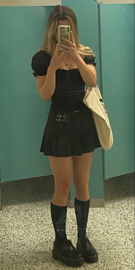 girl wearing puffy sleeve black top with black corset and vertical stripe skirt with clasp and black knee high socks and oxford low doc martens with tote bag mirror photo in a public washroom Pin Stripe Mini Skirt, Mini Skirt Knee High Socks Outfit, Knee High Socks Outfit Grunge, Pin Stripe Skirt Outfit, Knee High Doc Martens Outfits, Black Knee High Socks Outfit, Knee High Doc Martens, Corset Skirt Outfit, Low Doc Martens