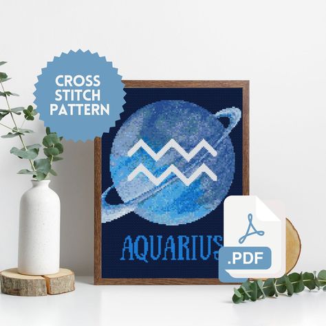 Cross stitch pattern in PDF with the sign of the zodiac Aquarius and its planet Uranus. The final design is placed in a frame, with a dark canvas. Zodiac Cross Stitch, Aquarius Astrology, Astrology Aquarius, Color Guide, Zodiac Signs Aquarius, Cross Stitch Pattern, Stitch Pattern, Zodiac Sign, Cross Stitch Patterns