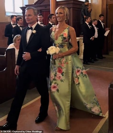 A mother-of-the bride has sparked fierce controversy online after wearing a flamboyant dress to her daughter's wedding. A video taken at the event with the caption 'The most stunning MOB dress we've ever seen!!!!' showed Lori DeWitt, 53, strutting down the aisle in her bespoke Audrey + Brooks outfit Romantic Mother Of The Bride Dresses, Elegant Mob Dresses, Audrey And Brooks Dress, Unusual Mother Of The Bride Dresses, Preppy Mother Of The Bride Dress, Mother Of The Bride Dresses Formal, Mother Of Bride Summer Wedding, Mother Of The Bride Aesthetic, Mom Of The Bride Dresses Summer