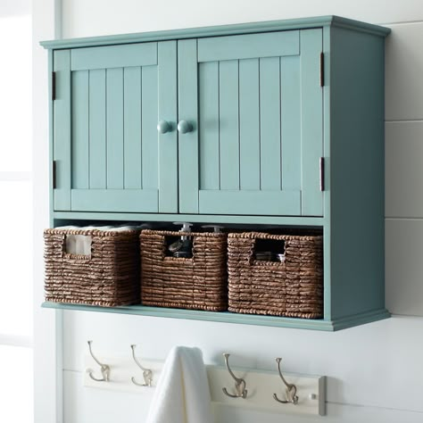 Storage doesn't have to be stark. Our handsome wood cabinet features three hand-woven banana leaf baskets and upper wainscot-detailed doors. Sized to fit perfectly above your toilet and hide all your powder room essentials. Bathroom Cabinets Over Toilet, Bathroom Storage Over Toilet, Small Bathroom Storage Solutions, Bathroom Wall Storage, Wall Storage Cabinets, Room Storage Diy, Bathroom Storage Solutions, Over Toilet, Wood Storage Cabinets