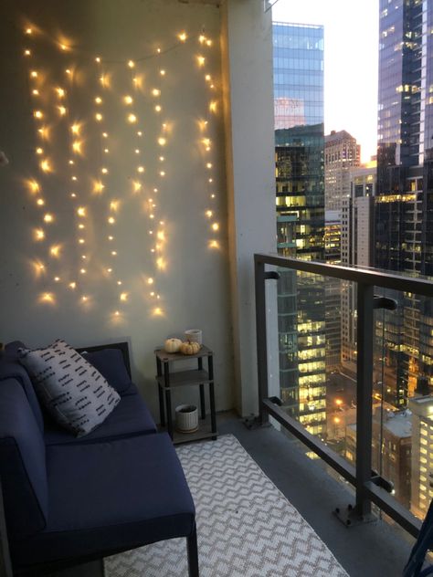 Balcony with couch and twinkle lights overlooking the city High Rise Patio Ideas, High Rise Apartment Balcony, High Rise Balcony Ideas, City Apartment Balcony, Lights Balcony Apartment, High Rise Balcony Decor, Apartment Balcony Aesthetic, High Rise Balcony, Chicago Balcony