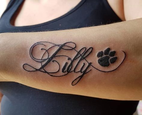 20 Best Dog Name Tattoo Designs – The Paws Dog Name Tattoos For Women, Dogs Name Tattoo Ideas, Dog Paw Tattoo With Name, Tattoo For My Dog Memories, Lilly Name Tattoo, Dog Memorial Tattoos With Name, Pet Name Tattoo, Dog Name Tattoo Ideas, Doggie Tattoos