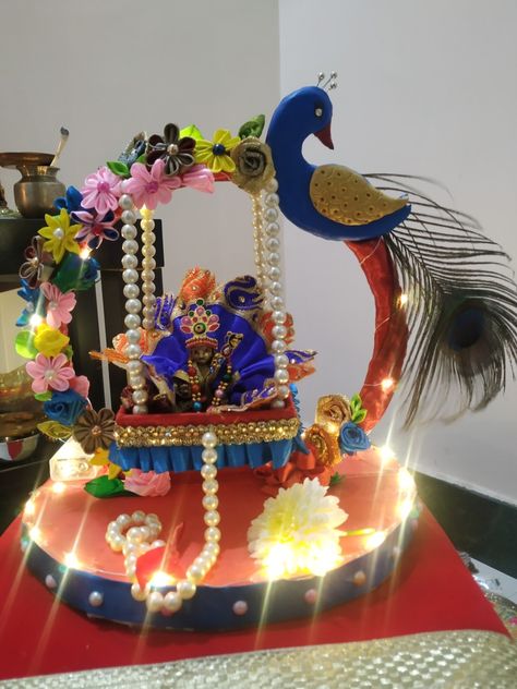 Jhula made from cardboard. Flowers are made of satin ribbon and peacock from home made paper clay Jhula For Kanha Ji, Janmashtami Jhula Making, Ladu Gopal Jhula Decoration, Krishna Accessories, Jhula Decoration, Home Made Paper, Cardboard Flowers, Krishna Jhula, Sia Songs